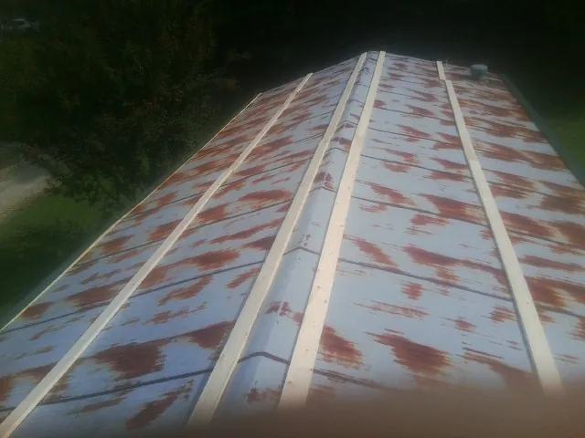 Rusted metal roof panels with new wood purlins before replacement — Storm Damage Roof Repair in Conestoga by Roofing Brothers