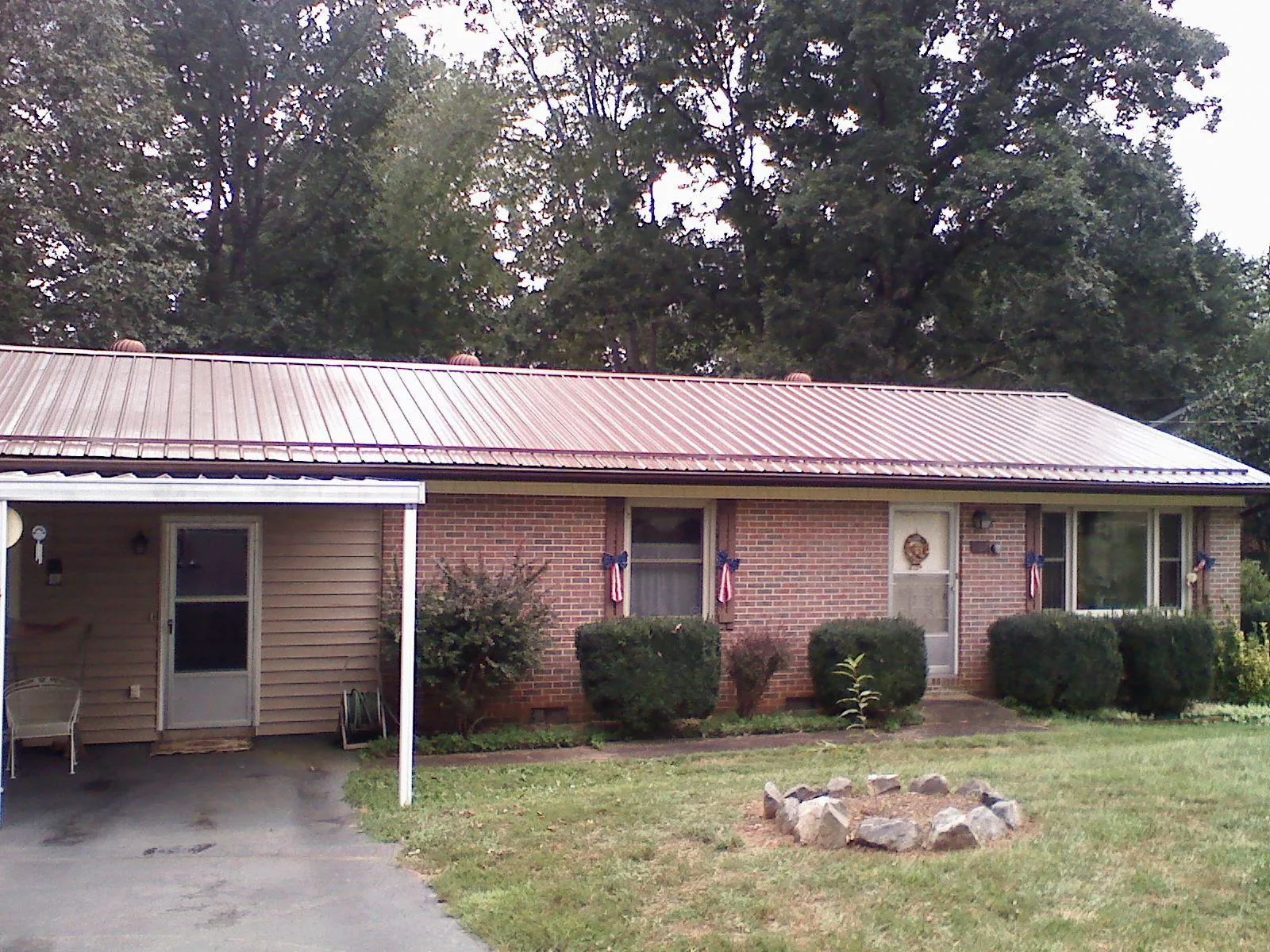 Bronze metal roof and carport on a brick ranch home — Roof Repair work by our crew in Conestoga